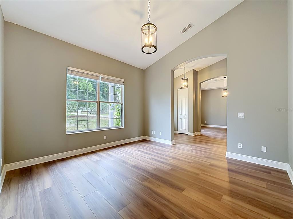 28549 Shirley Shores Road Tavares, FL 32778 - Photo 11 of 65 a view of an empty room with wooden floor and a window