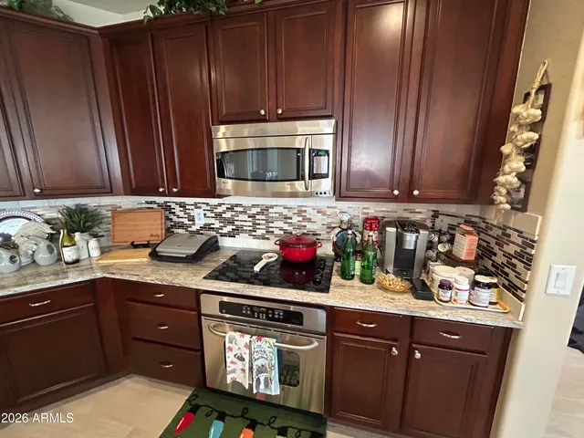 a kitchen with stainless steel appliances granite countertop wooden cabinets and sink