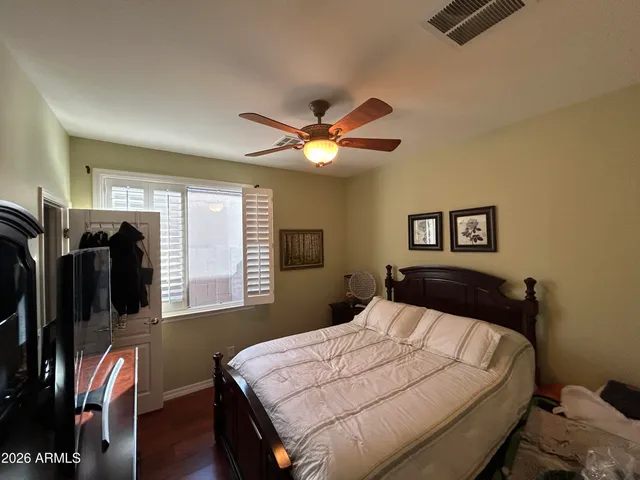 a bedroom with a large bed and a ceiling fan