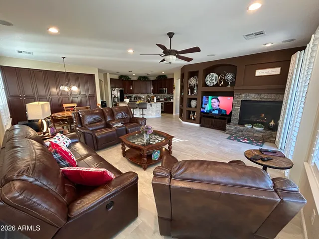 a living room with furniture a flat screen tv and a floor to ceiling window