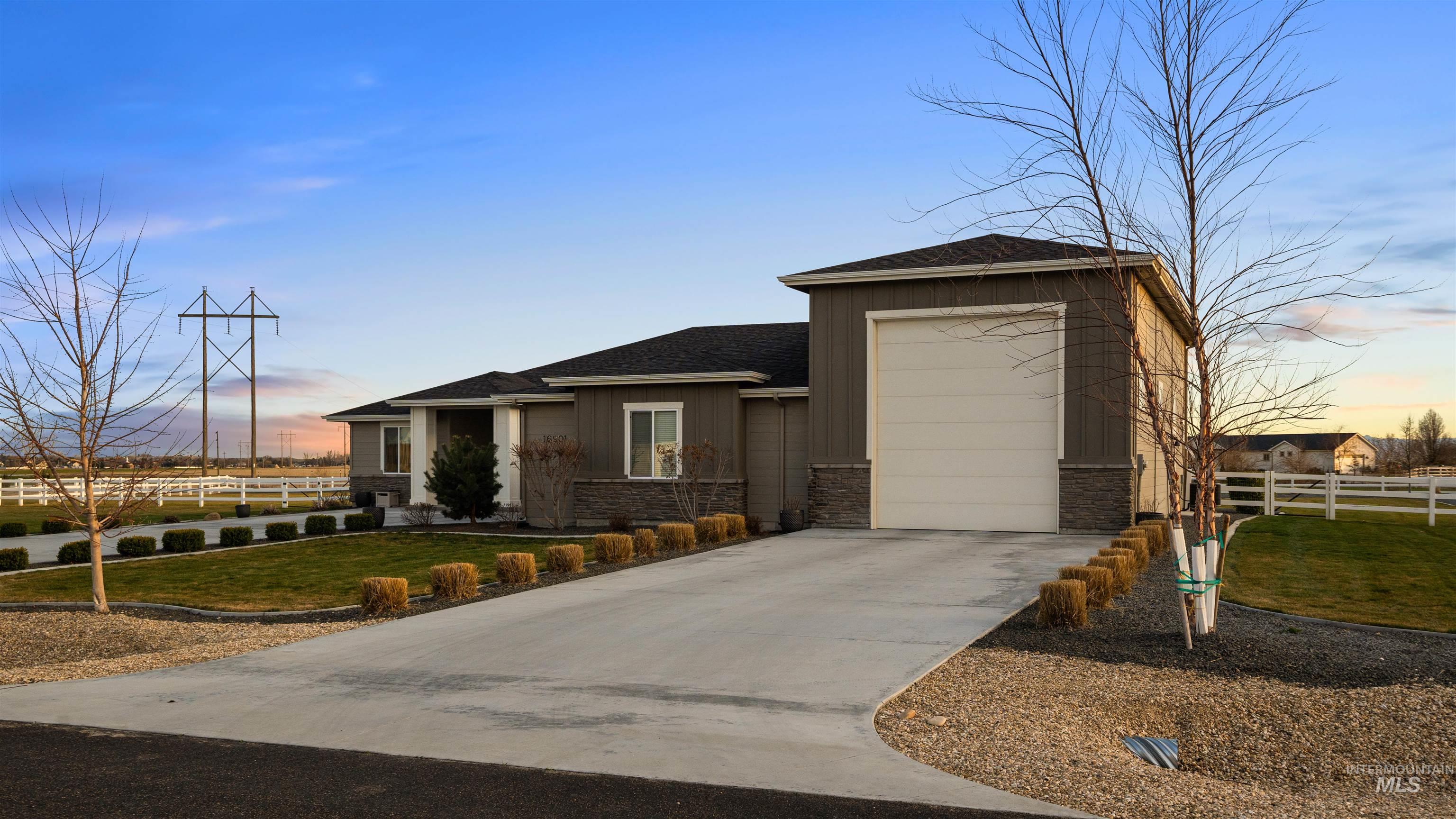 16901 Spring Meadow Drive Caldwell, ID 83607 - Photo 5 of 50 View of front of property featuring a shingled roof, stone siding, driveway, and board and batten siding