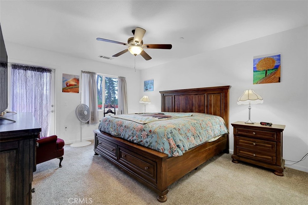 14141 Racine Circle Magalia, CA 95954 - Photo 24 of 53 a spacious bedroom with a bed and a chandelier