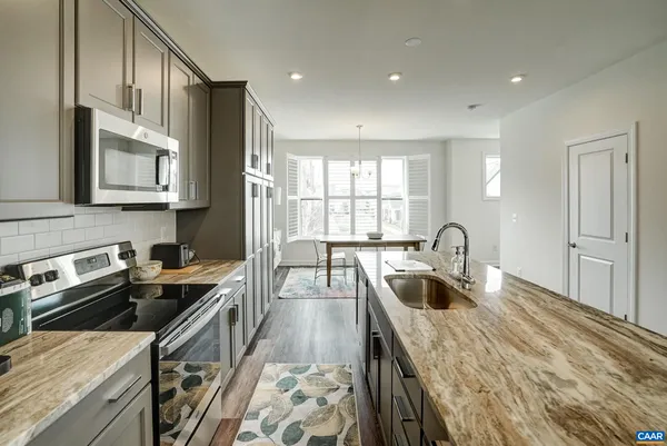 a kitchen with granite countertop a sink stove and cabinets