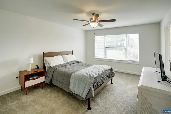 a spacious bedroom with a bed and a window