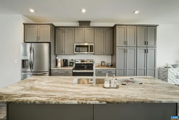 a kitchen with stainless steel appliances granite countertop a sink refrigerator and microwave