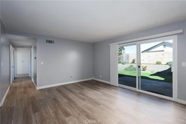 wooden floor fireplace and windows in an empty room