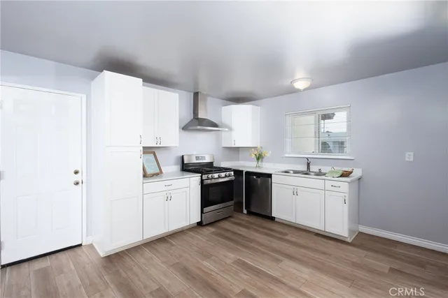 a kitchen with stainless steel appliances granite countertop a sink stove and cabinets