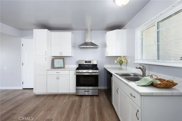 an empty room with wooden floor fireplace and windows