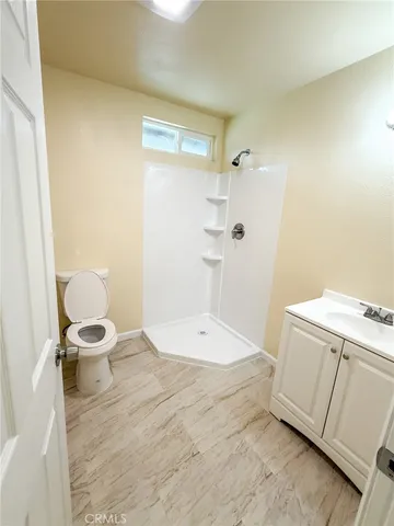 a bathroom with a granite countertop sink toilet and shower