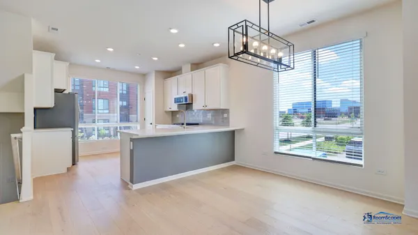 a kitchen with kitchen island a large counter top space appliances and a window