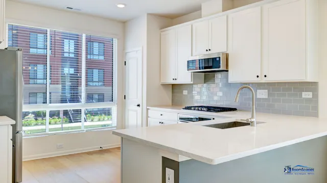 a kitchen with stainless steel appliances a stove a sink and a microwave