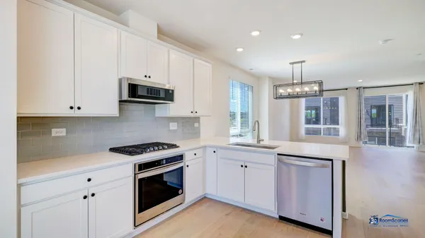 a kitchen with granite countertop white cabinets and stainless steel appliances