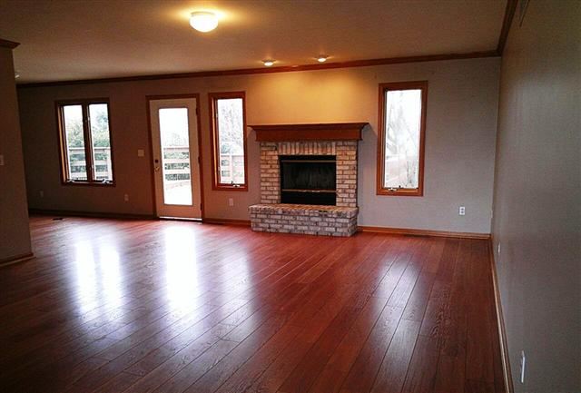 5168 East Walden Road Byron, IL 61010 - Photo 2 of 9 an empty room with wooden floor and a fireplace