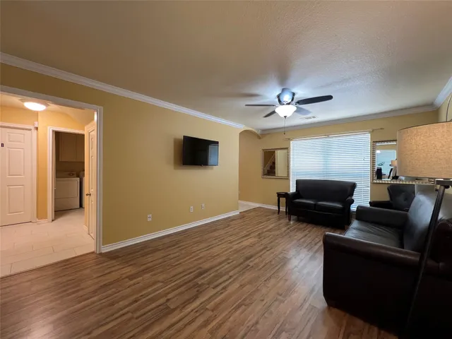 a view of an empty room with wooden floor and windows