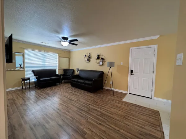 a living room with furniture and a wooden floor