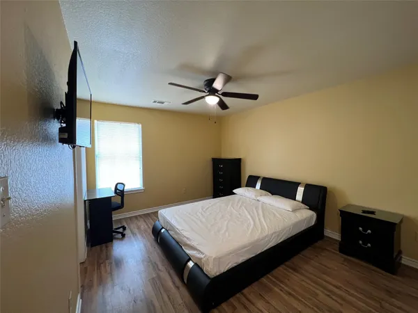 a bedroom with a bed and wooden floor