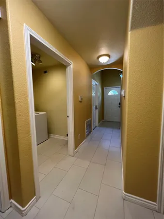 a view of a hallway with wooden cabinets