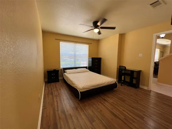 a bedroom with a bed and wooden floor