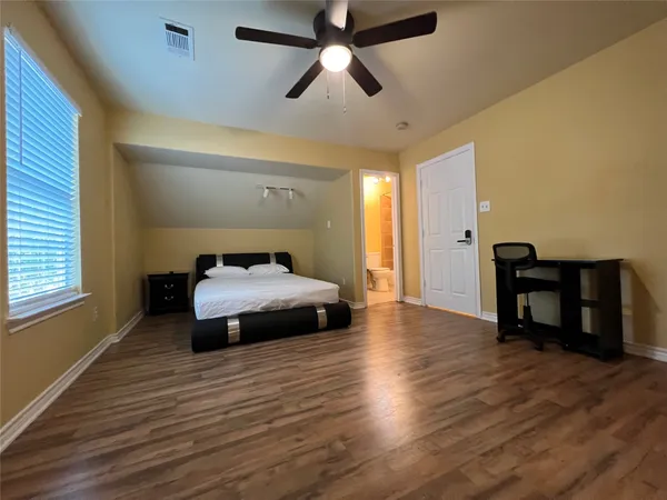 a bedroom with a bed and wooden floor