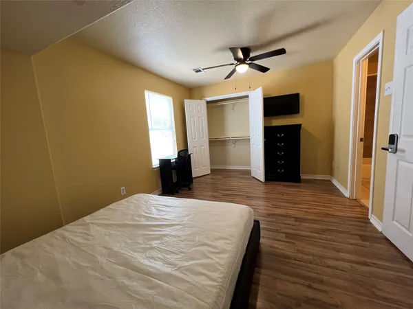 a large bedroom with wooden floor
