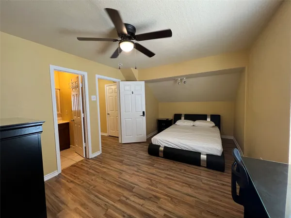 a bedroom with a bed and a ceiling fan