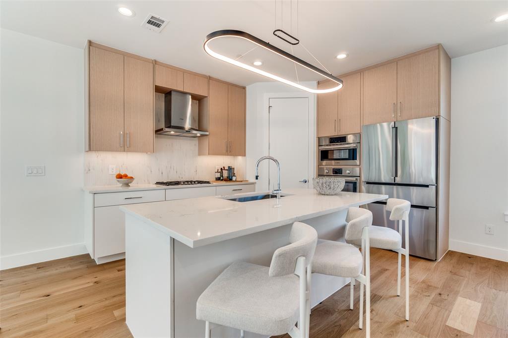 3940 Spring Valley Road, Unit 1 Farmers Branch, TX 75244 - Photo 11 of 19 a kitchen with stainless steel appliances kitchen island granite countertop a sink and cabinets