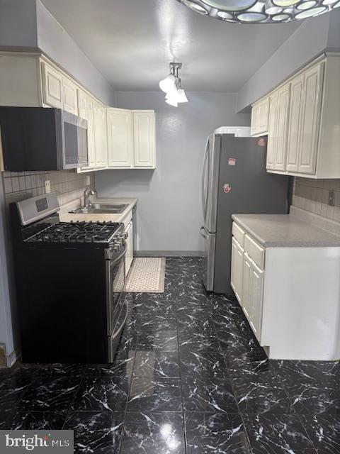 300 Byberry Road, Unit 202 Philadelphia, PA 19116 - Photo 13 of 32 a kitchen with a sink a stove a microwave and cabinets