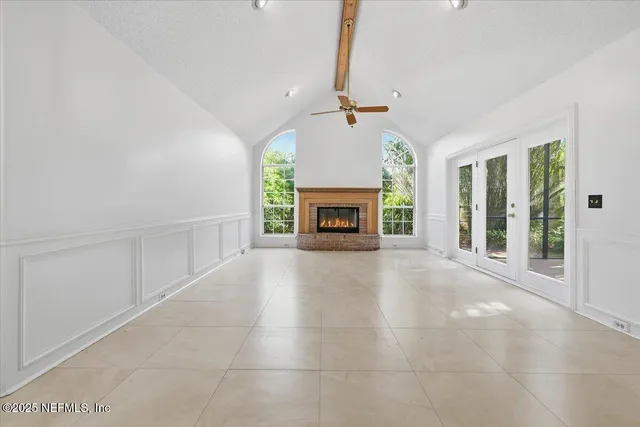 a view of an empty room with a fireplace and a window