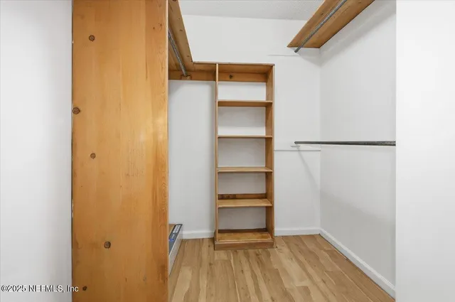 a view of walk in closet with empty racks