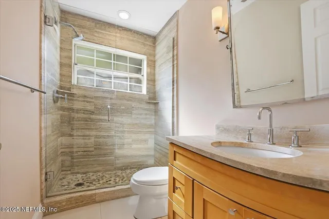 a bathroom with a granite countertop sink toilet and shower