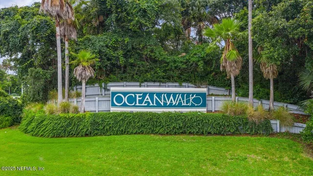 a view of sign board with yard and trees