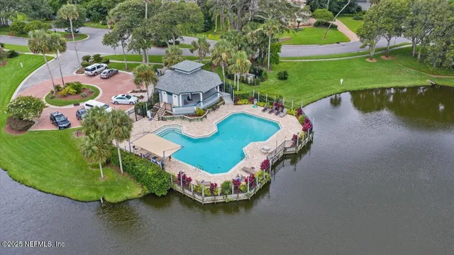 an aerial view of a house with a garden and lake view