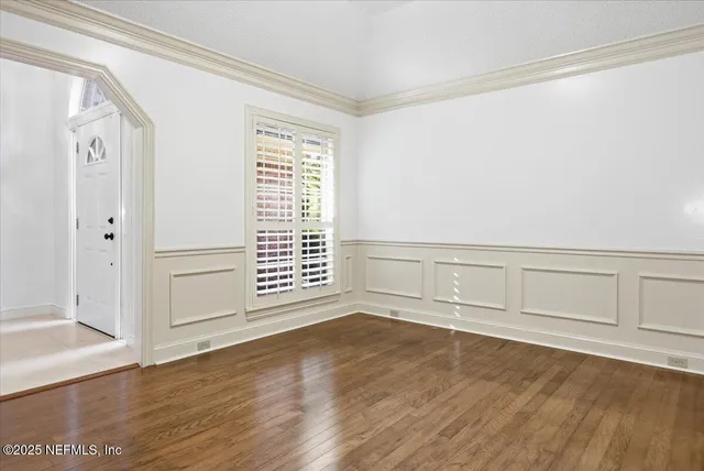 an empty room with wooden floor and white walls