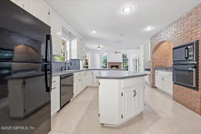 a kitchen with granite countertop white cabinets and white appliances