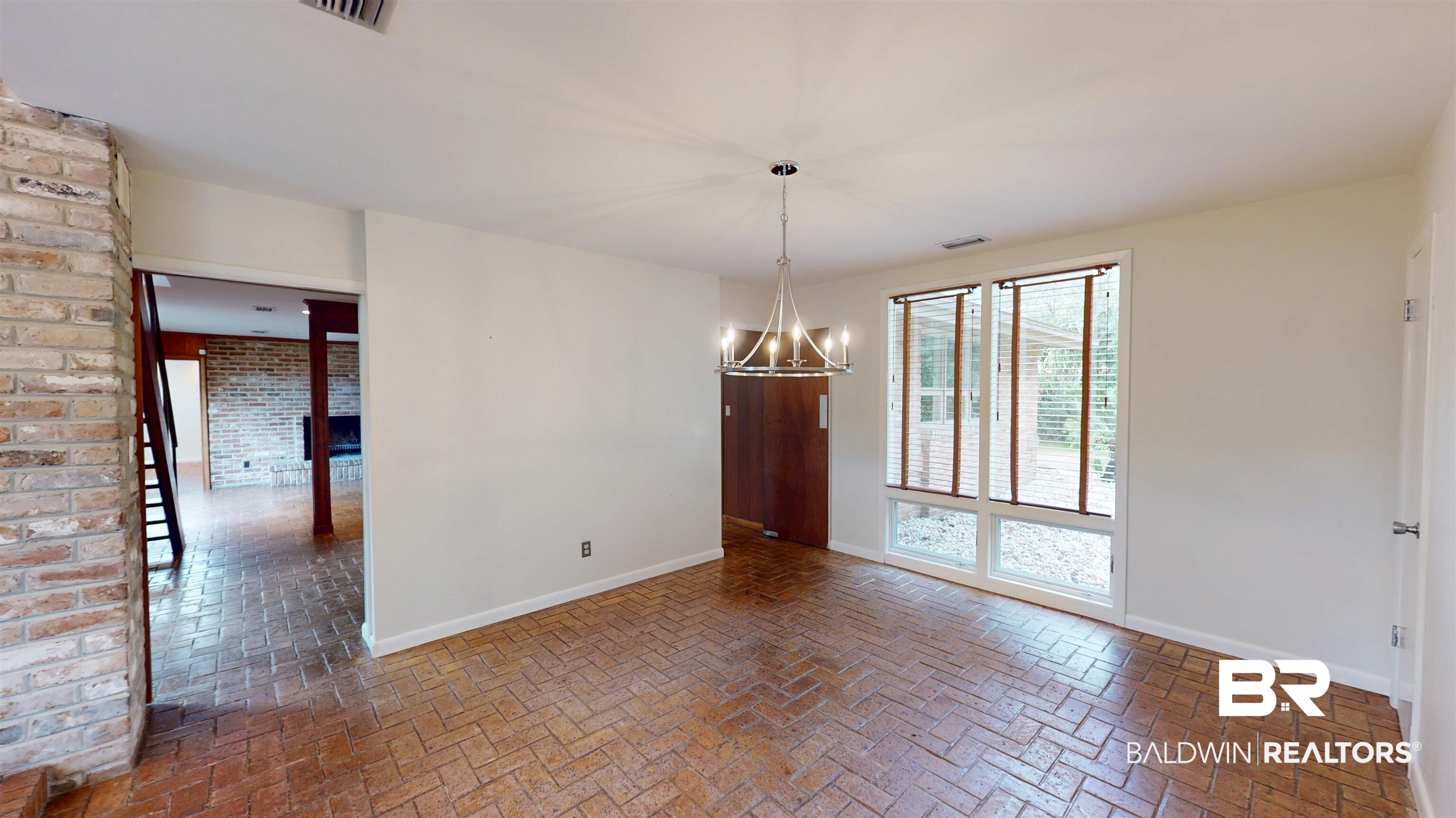 15 Spring Bank Road Mobile, AL 36608 - Photo 15 of 58 Unfurnished room featuring a chandelier, brick flooring, and brick wall