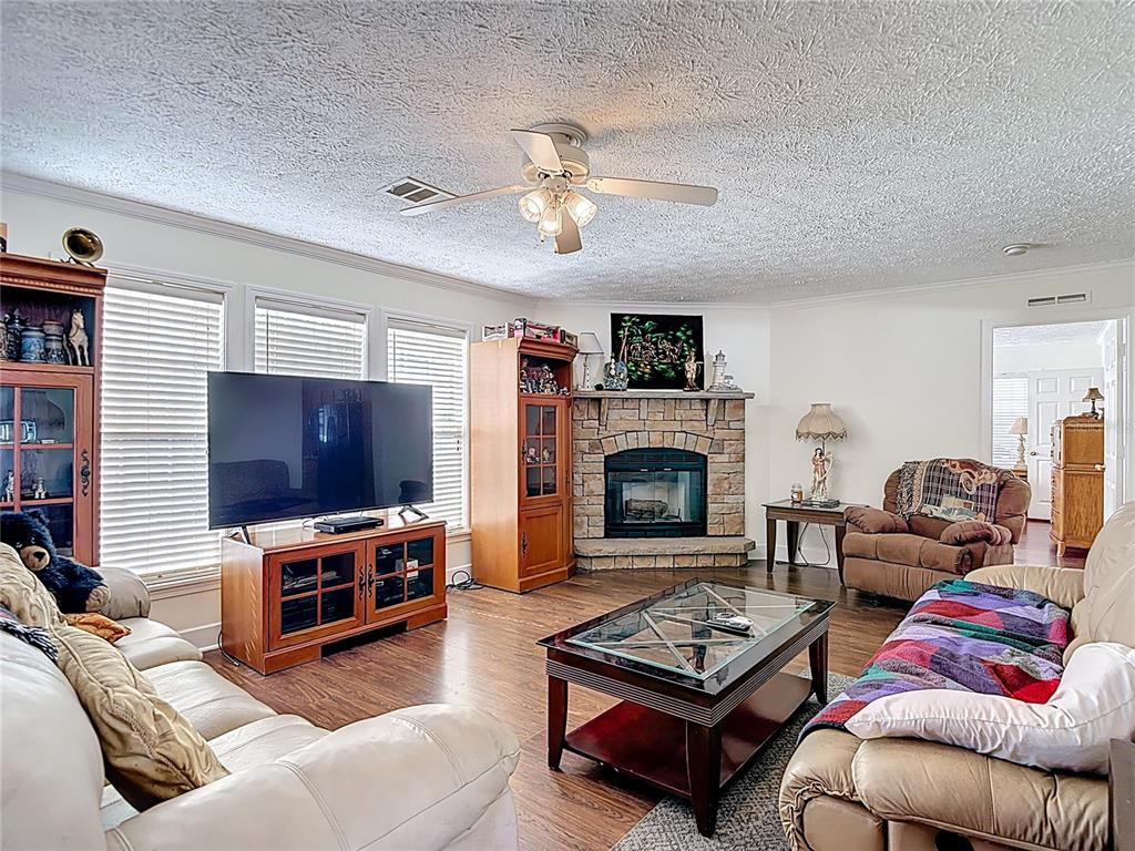15821 Archer Street Hudson, FL 34667 - Photo 20 of 77 a living room with furniture a flat screen tv and a fireplace