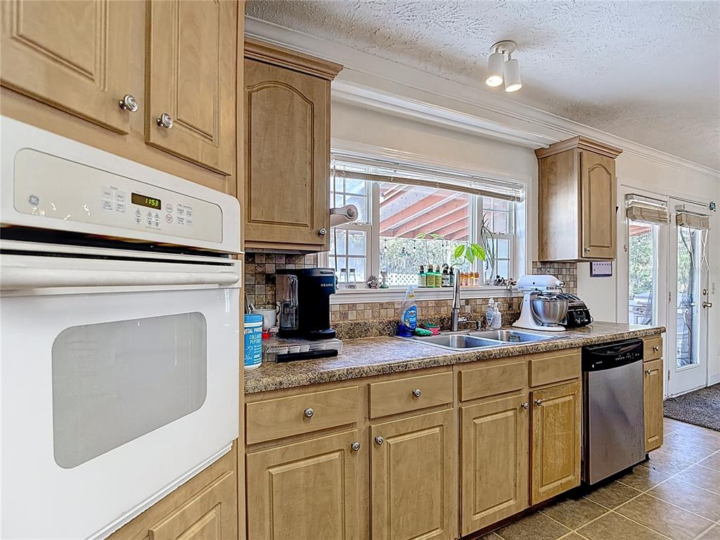 15821 Archer Street Hudson, FL 34667 - Photo 26 of 77 a kitchen with cabinets appliances a sink and a window