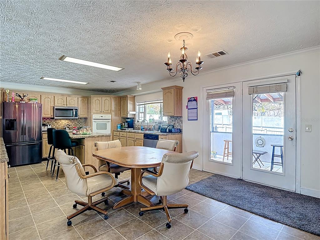 15821 Archer Street Hudson, FL 34667 - Photo 35 of 77 a view of a dining room with furniture and a chandelier