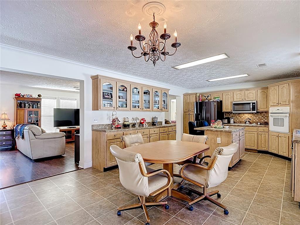 15821 Archer Street Hudson, FL 34667 - Photo 36 of 77 a view of a dining room kitchen with furniture and chandelier