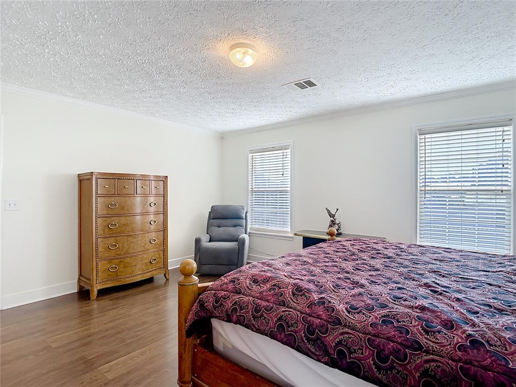 15821 Archer Street Hudson, FL 34667 - Photo 48 of 77 a bedroom with a bed and wooden floor