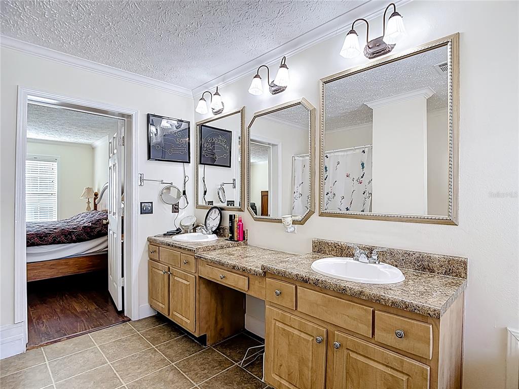 15821 Archer Street Hudson, FL 34667 - Photo 55 of 77 a en suite bathroom with a granite countertop sink and a mirror