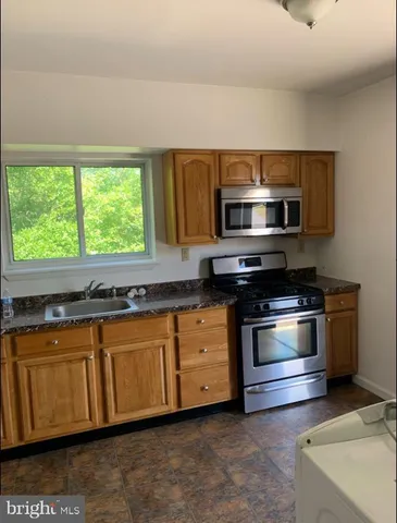 a kitchen with stainless steel appliances granite countertop a stove microwave and sink