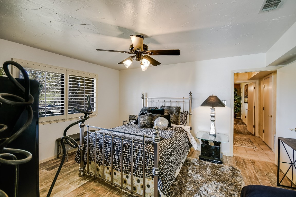 333 Quail Run Court Spicewood, TX 78669 - Photo 18 of 37 a bedroom with a bed and a chandelier