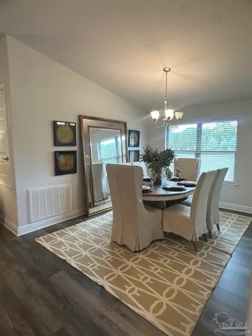 a view of a dining room with furniture and chandelier