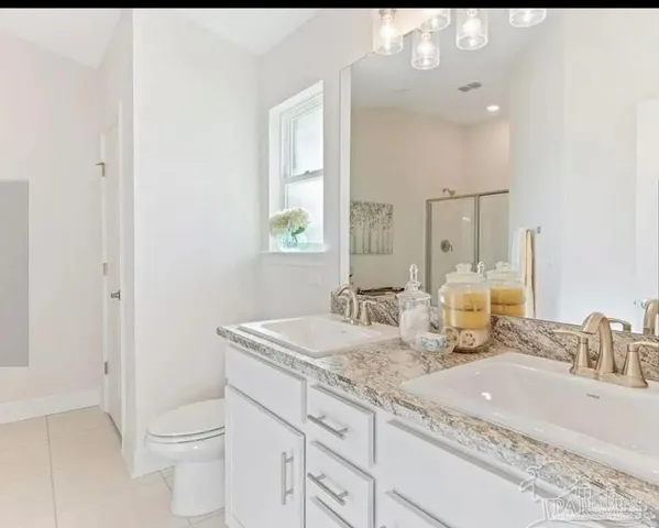 a bathroom with a granite countertop sink a toilet and a mirror