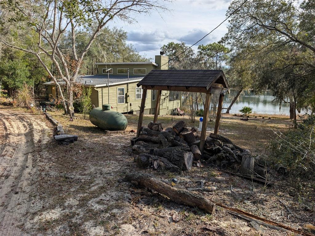 14730 Southeast 61st Street Road Ocklawaha, FL 32179 - Photo 60 of 88 a view of a patio with chair and table and chairs under an umbrella