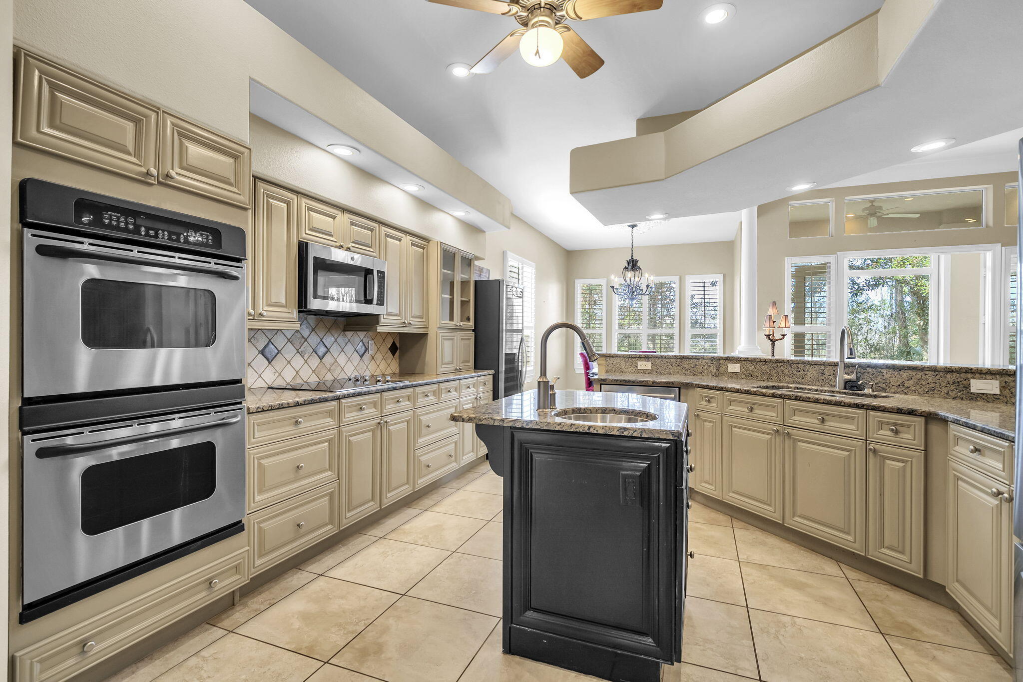4595 Sailmaker Lane Destin, FL 32541 - Photo 15 of 50 a kitchen with stainless steel appliances granite countertop a stove sink and cabinets