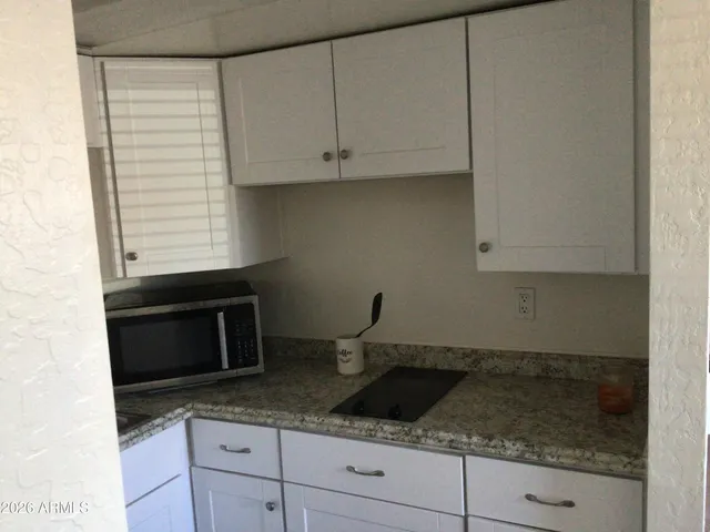 a kitchen with granite countertop a sink and cabinets
