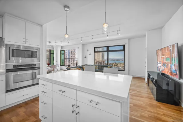 a large kitchen with kitchen island a large counter space stainless steel appliances and cabinets