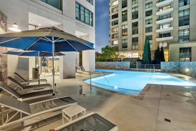 a large swimming pool that has lawn chairs